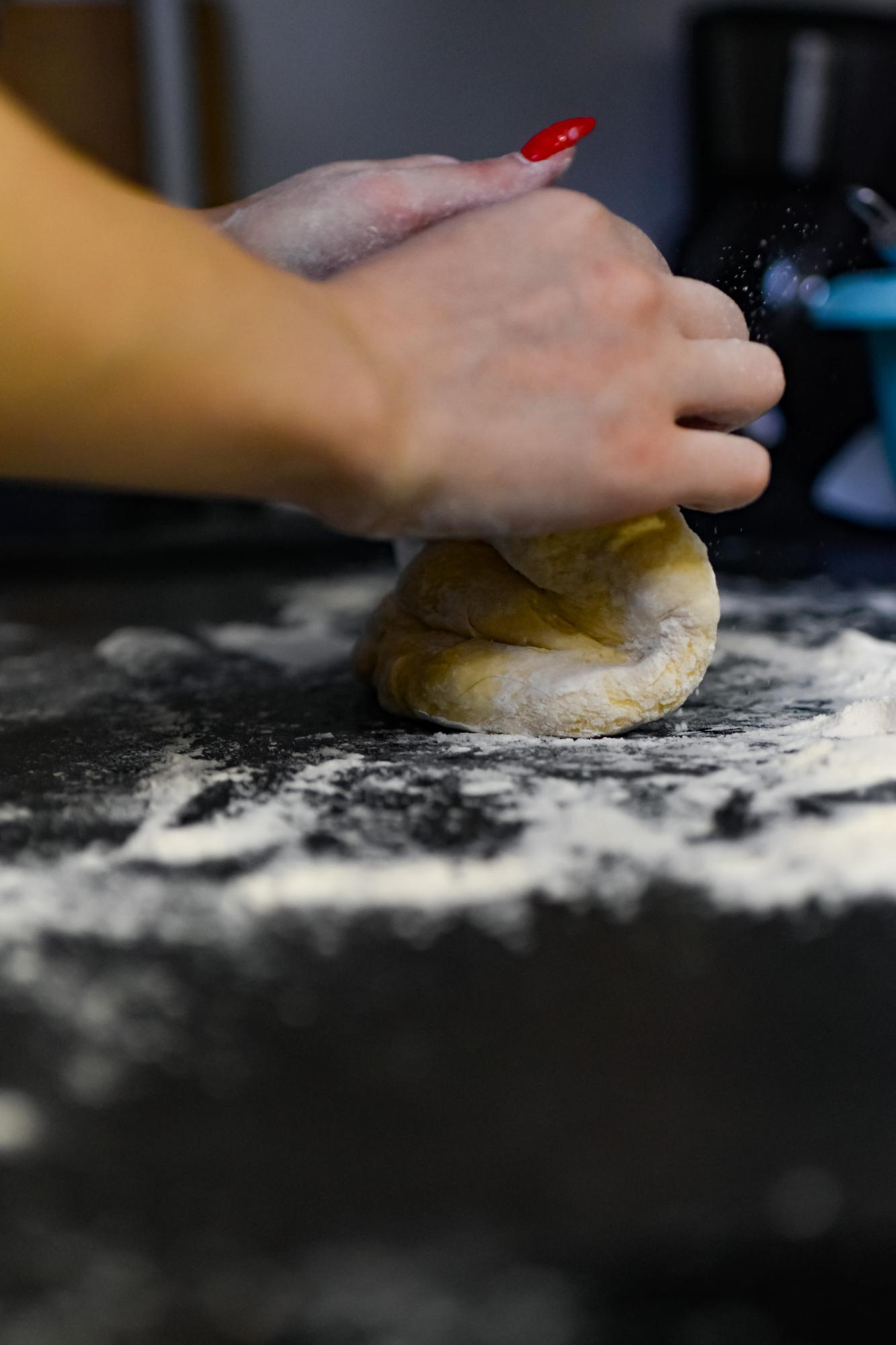Dettaglio mani che impastano con precisione